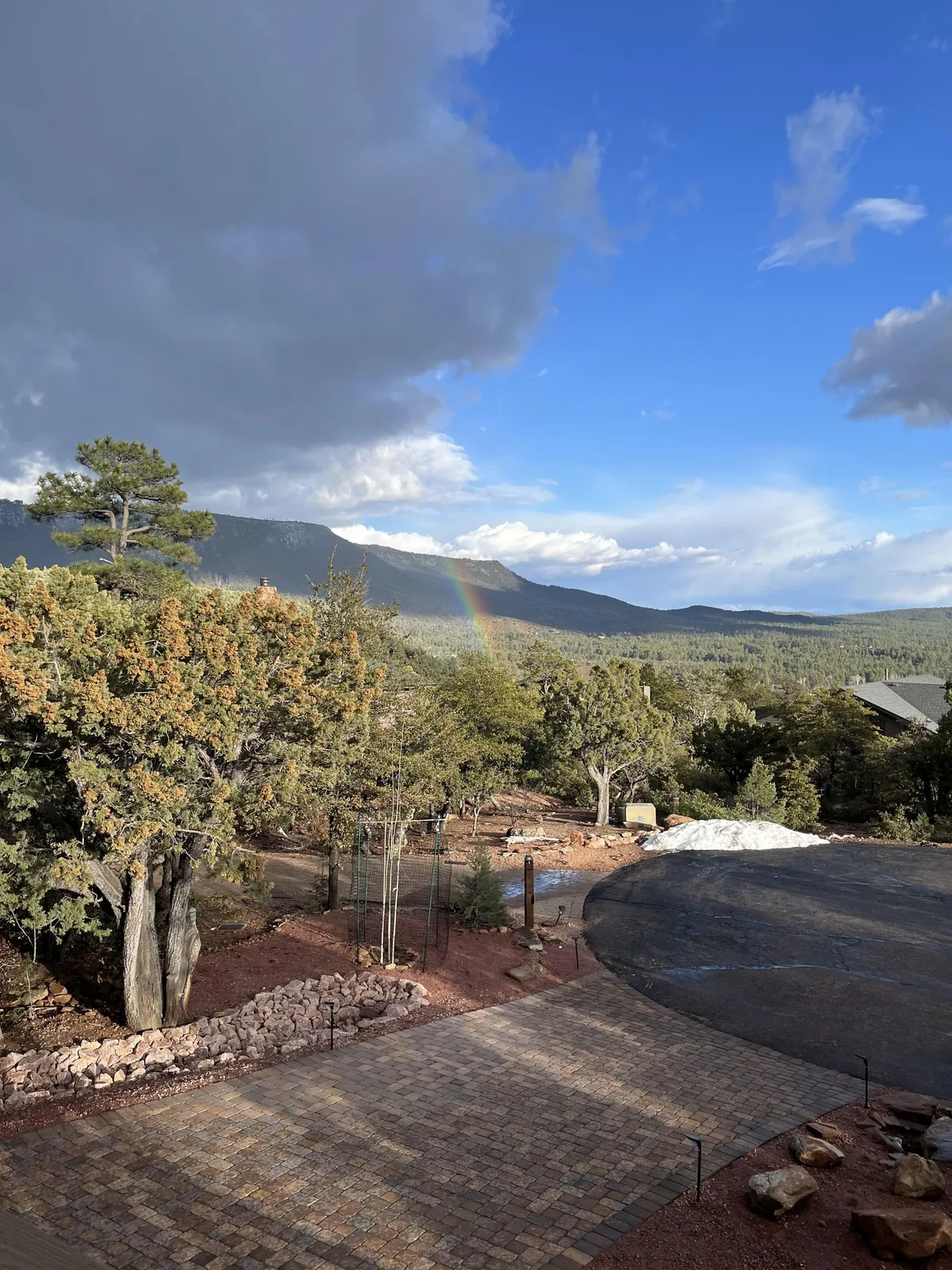This image showcases a vivid rainbow arching over a mountain view, with trees and a paved path in the foreground. The peaceful scene captures the beauty of Pine’s natural surroundings and hints at the abundance of outdoor activities nearby.